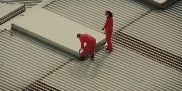 Activists stand on roof in "To Kill a War Machine"